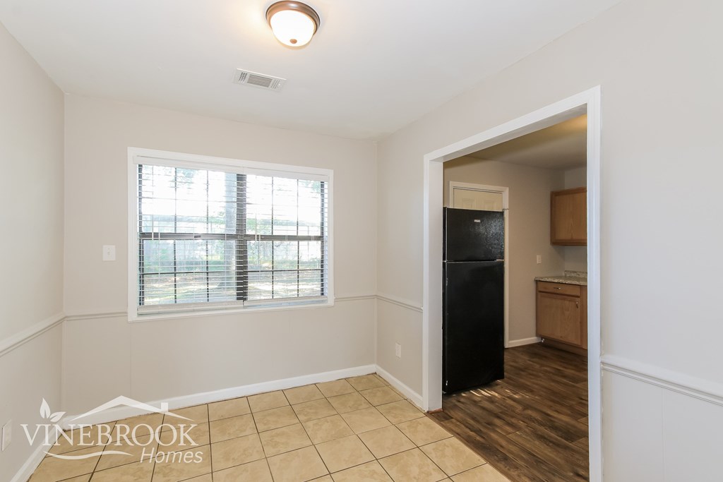 a kitchen with a large window and a black refrigerator